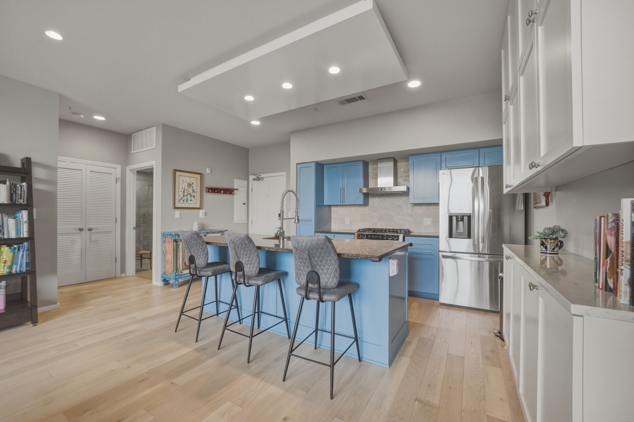 1600 Barton Springs Road, Unit 4305 Austin, TX 78704 - Photo 4 of 26 a kitchen with stainless steel appliances a table and chairs in it