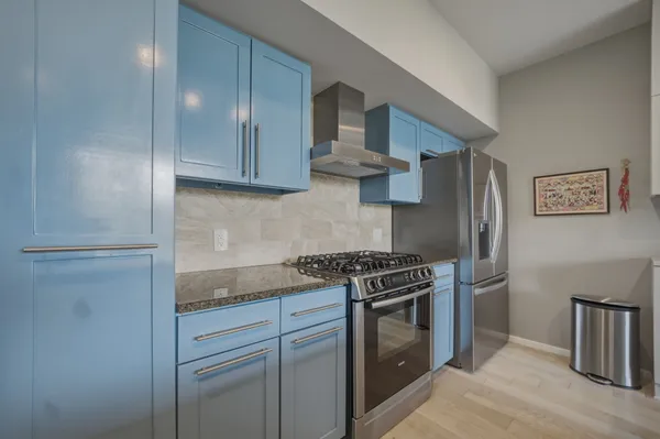 a kitchen with stainless steel appliances a table and chairs in it