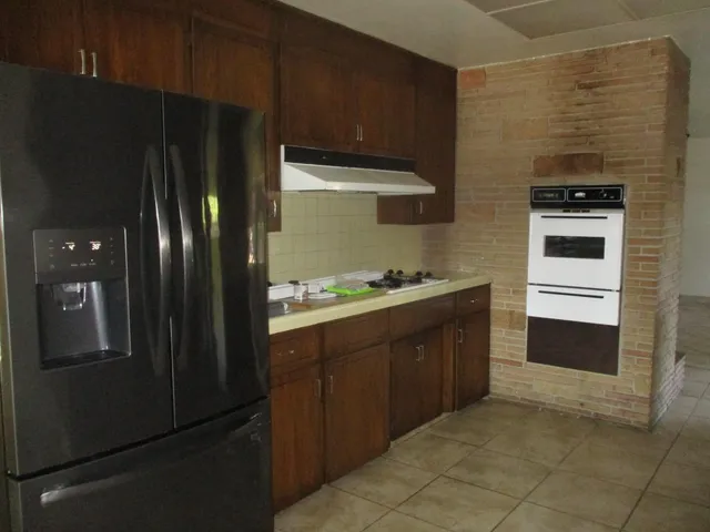 a kitchen with stainless steel appliances granite countertop a refrigerator and a stove