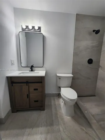 a bathroom with a toilet a sink and mirror