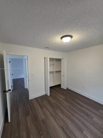an empty room with wooden floor and closet