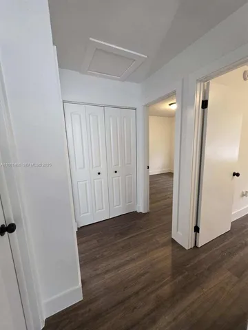 an empty room with wooden floor and entrance