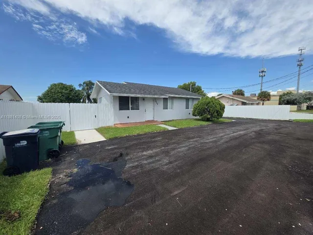 a view of a house with backyard and a yard
