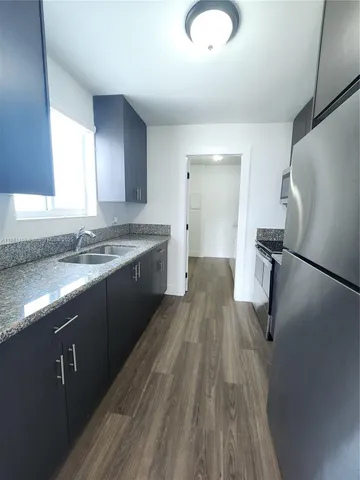 a kitchen with stainless steel appliances granite countertop a sink stove and refrigerator