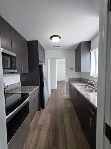 a large kitchen with a stove and a refrigerator