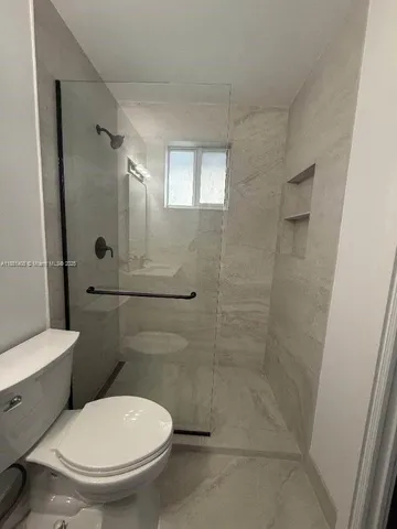 a white toilet sitting next to a bathroom sink