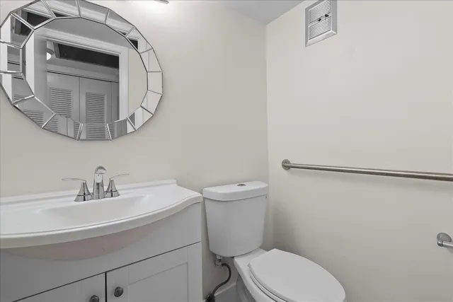 a bathroom with a sink a toilet and a mirror