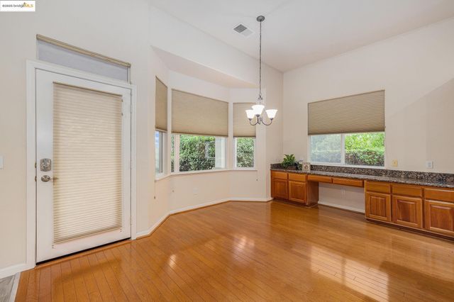 a large kitchen with kitchen island a large counter top space a sink stainless steel appliances and cabinets