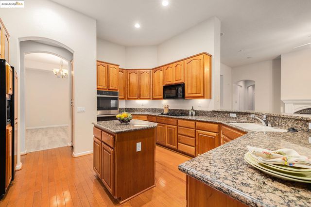 a kitchen with stainless steel appliances granite countertop sink stove and cabinets