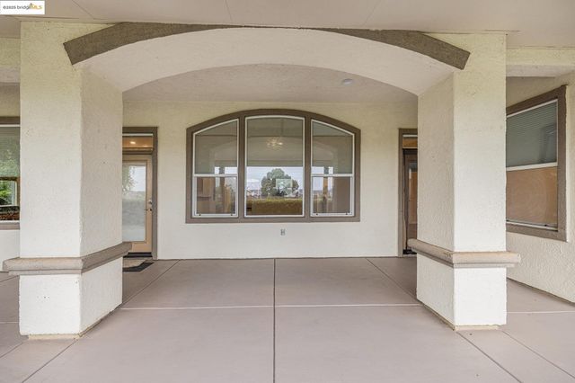 a view of a porch with furniture and floor to ceiling window