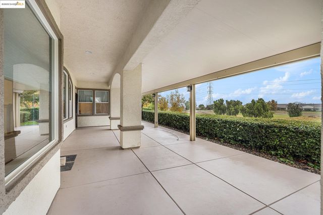 a view of a room with a large window and potted plants