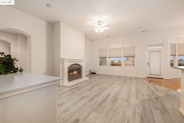a view of a livingroom with a fireplace a chandelier and wooden floor