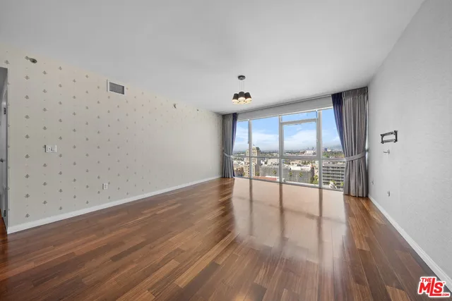 a kitchen with stainless steel appliances granite countertop a refrigerator a stove and a wooden floors