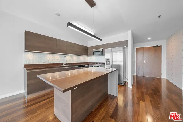 a view of an empty room with wooden floor and a closet