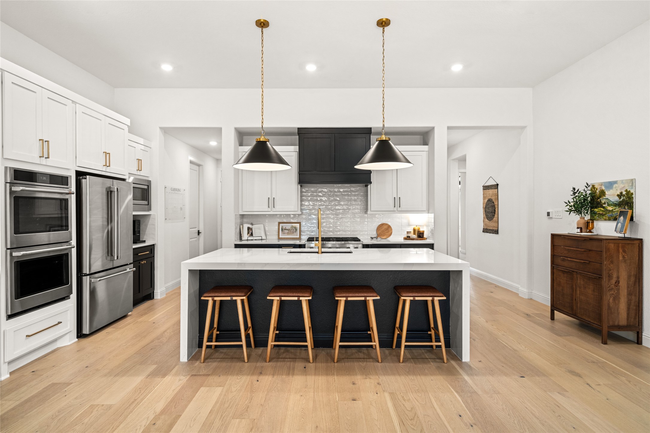 17461 Bayflower Conroe, TX 77385 - Photo 2 of 49 A gourmet kitchen with a large island, ample seating, stainless steel appliances, and a striking vent hood creates a modern, upscale feel.