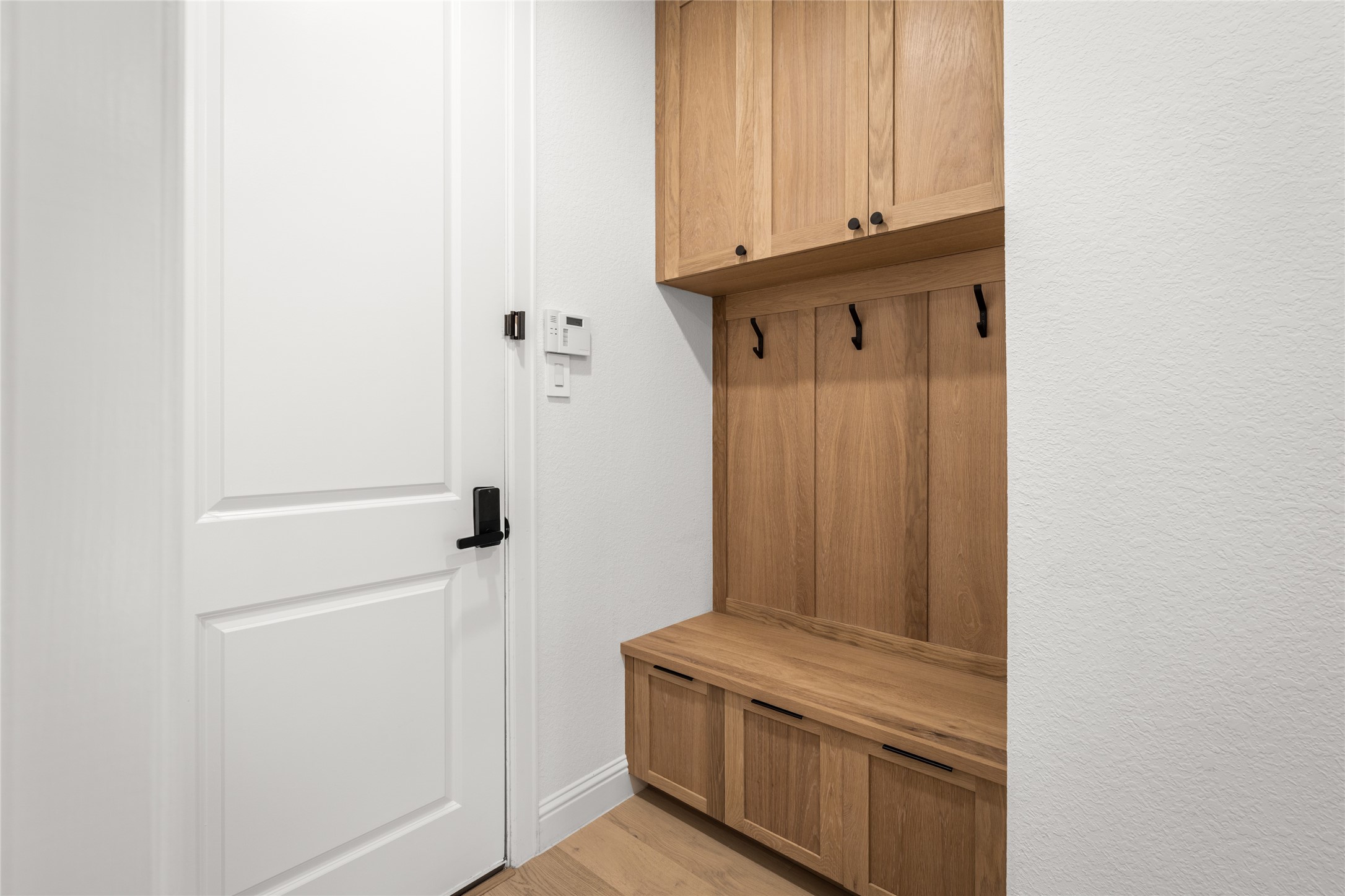 17461 Bayflower Conroe, TX 77385 - Photo 32 of 49 Custom mudroom with built-in bench seating, upper cabinetry, and wall hooks for easy organization.