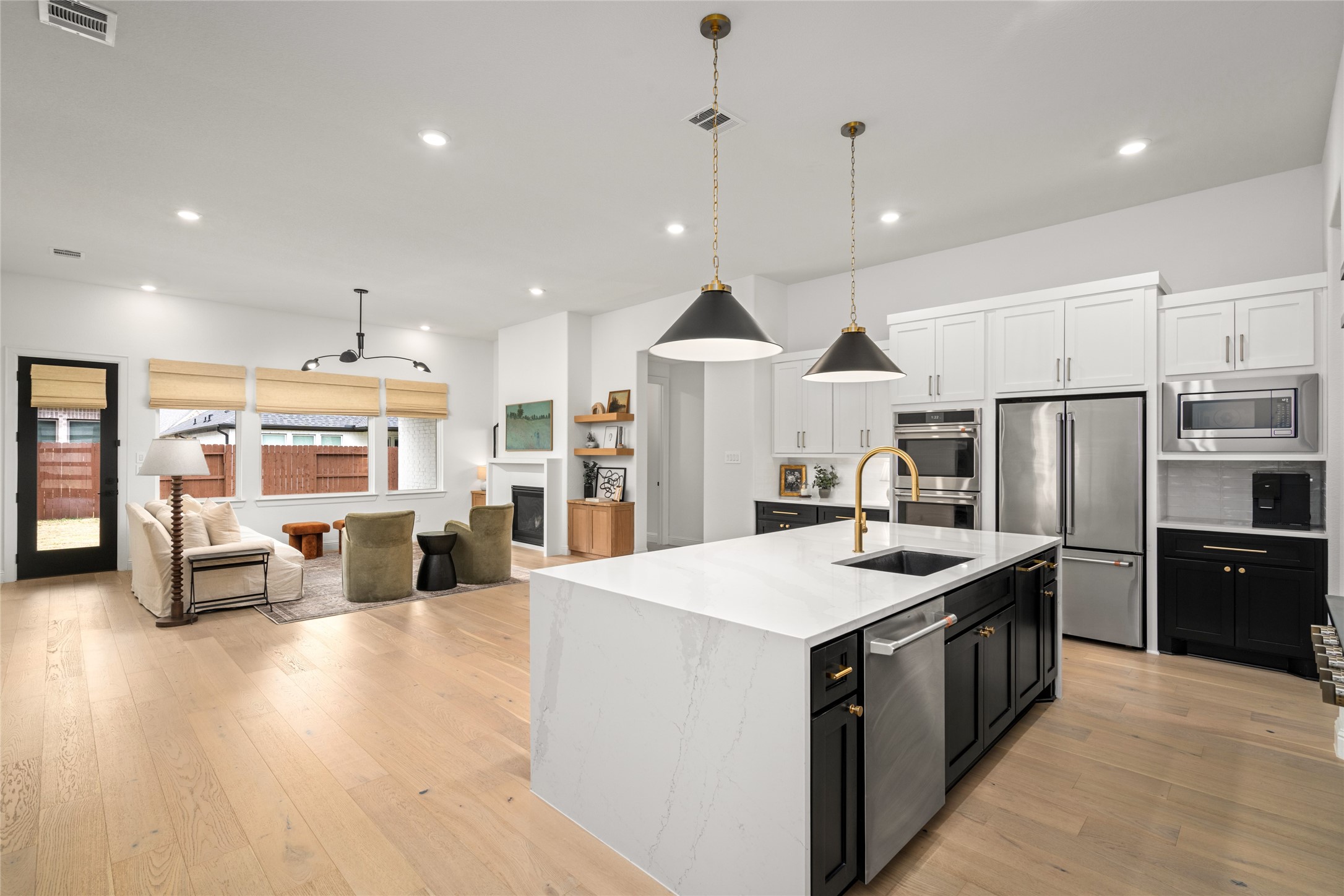 17461 Bayflower Conroe, TX 77385 - Photo 9 of 49 Very open concept kitchen with an oversized waterfall island, quartz countertops, and designer pendant lighting.