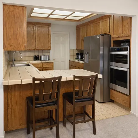 a kitchen with a table chairs refrigerator and cabinets