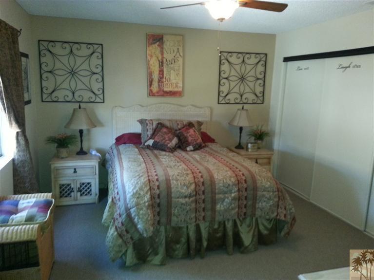 47800 Madison Street, Unit 99 Indio, CA 92201 - Photo 6 of 13 a bedroom with a bed and wall painting