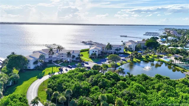 a view of a lake with lawn chairs and a table