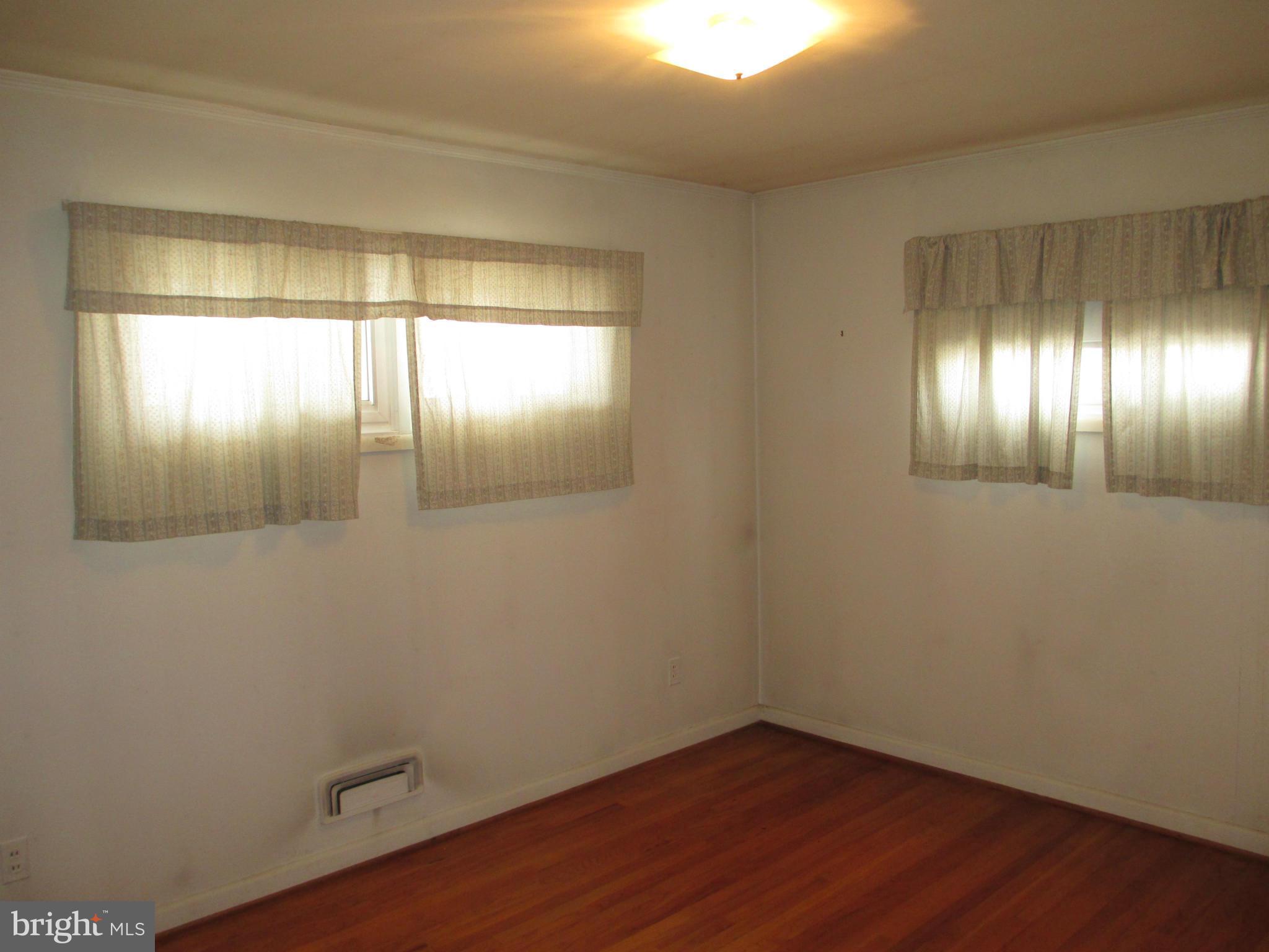 7426 Remoor Road Baltimore, MD 21207 - Photo 12 of 28 an empty room with wooden floor and windows
