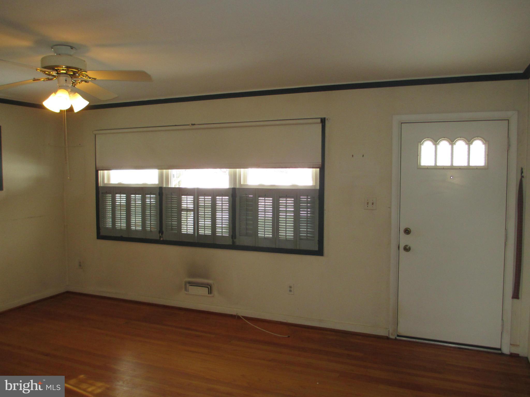 7426 Remoor Road Baltimore, MD 21207 - Photo 3 of 28 a view of an empty room with wooden floor and a window
