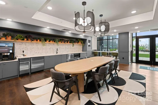 a dining room with wooden floor a chandelier a wooden table and chairs