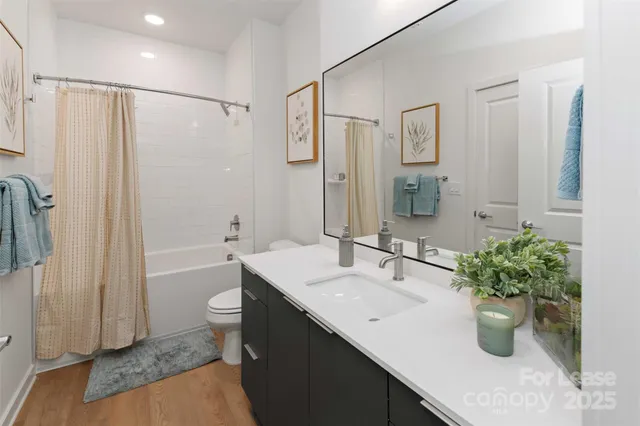 a bathroom with a granite countertop sink a toilet and shower