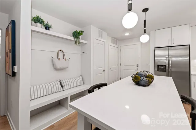 a kitchen with kitchen island a refrigerator and a wooden floor
