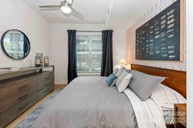 a bedroom with a bed and a large mirror on the dresser