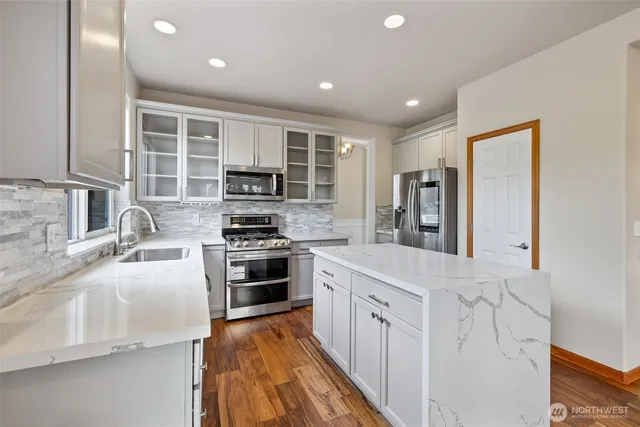 a kitchen with stainless steel appliances granite countertop a stove a sink and a refrigerator