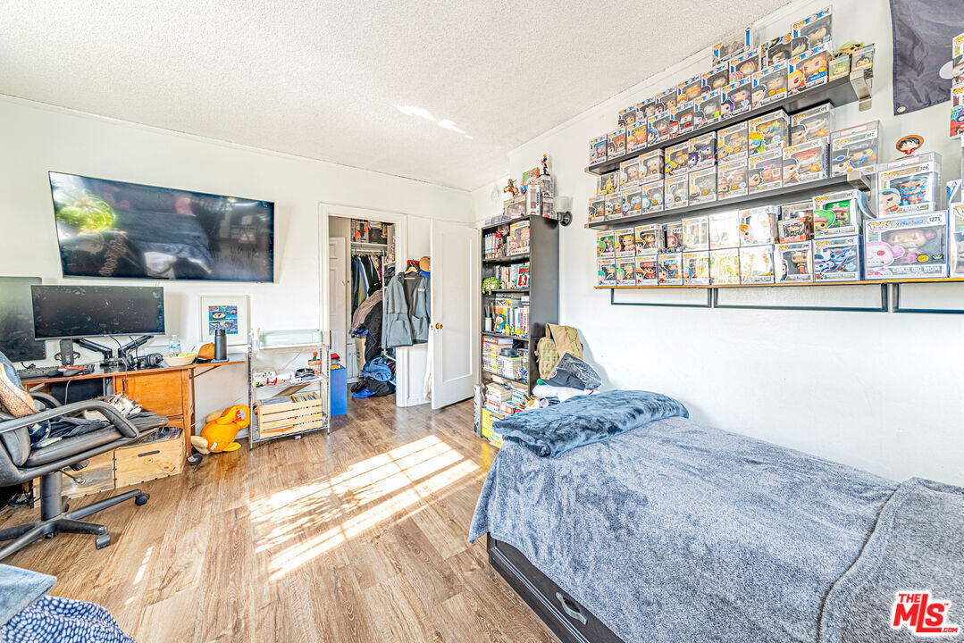 1618 South Burnside Avenue Los Angeles, CA 90019 - Photo 23 of 43 a spacious bedroom with a bed and wooden floor