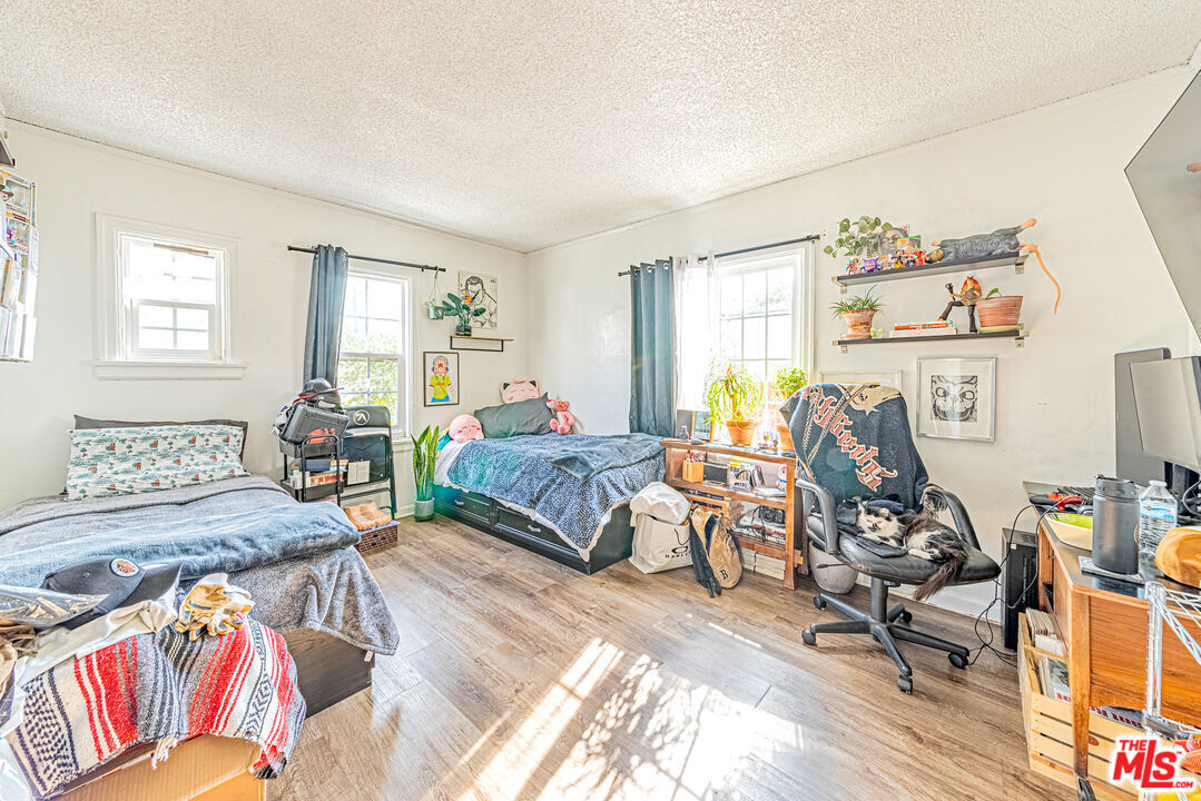 1618 South Burnside Avenue Los Angeles, CA 90019 - Photo 26 of 43 a bedroom with a bed and wooden floor