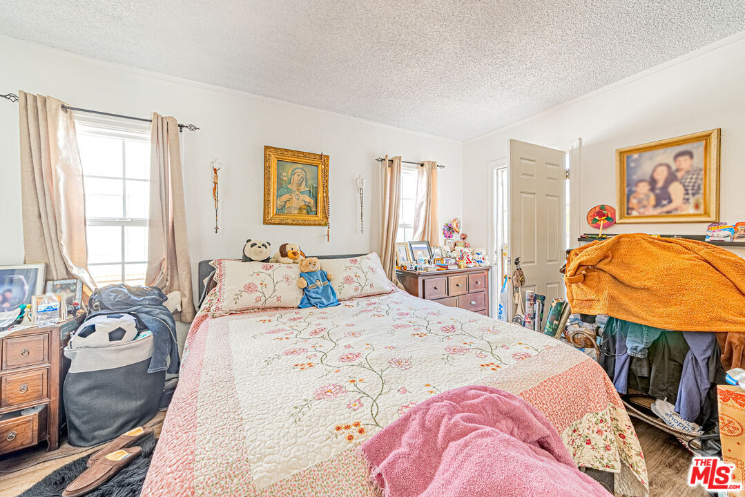 1618 South Burnside Avenue Los Angeles, CA 90019 - Photo 28 of 43 a bedroom with a bed a dresser with wooden floor