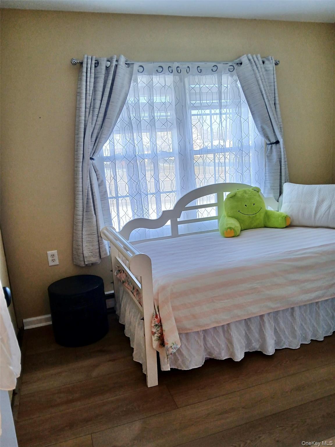 427 Aylesbury Court, Unit A Ridge, NY 11961 - Photo 14 of 16 a bedroom with a bed and wooden floor