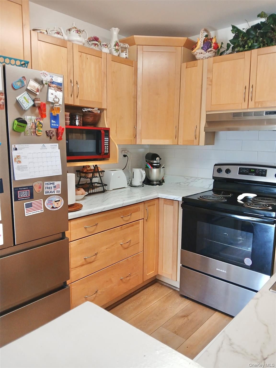 427 Aylesbury Court, Unit A Ridge, NY 11961 - Photo 2 of 16 a kitchen with stainless steel appliances a stove microwave and refrigerator
