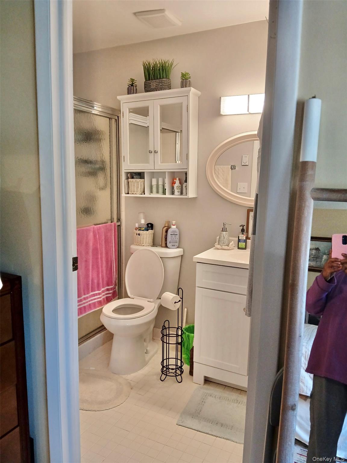 427 Aylesbury Court, Unit A Ridge, NY 11961 - Photo 10 of 16 a white toilet sitting next to a bathroom sink and a mirror