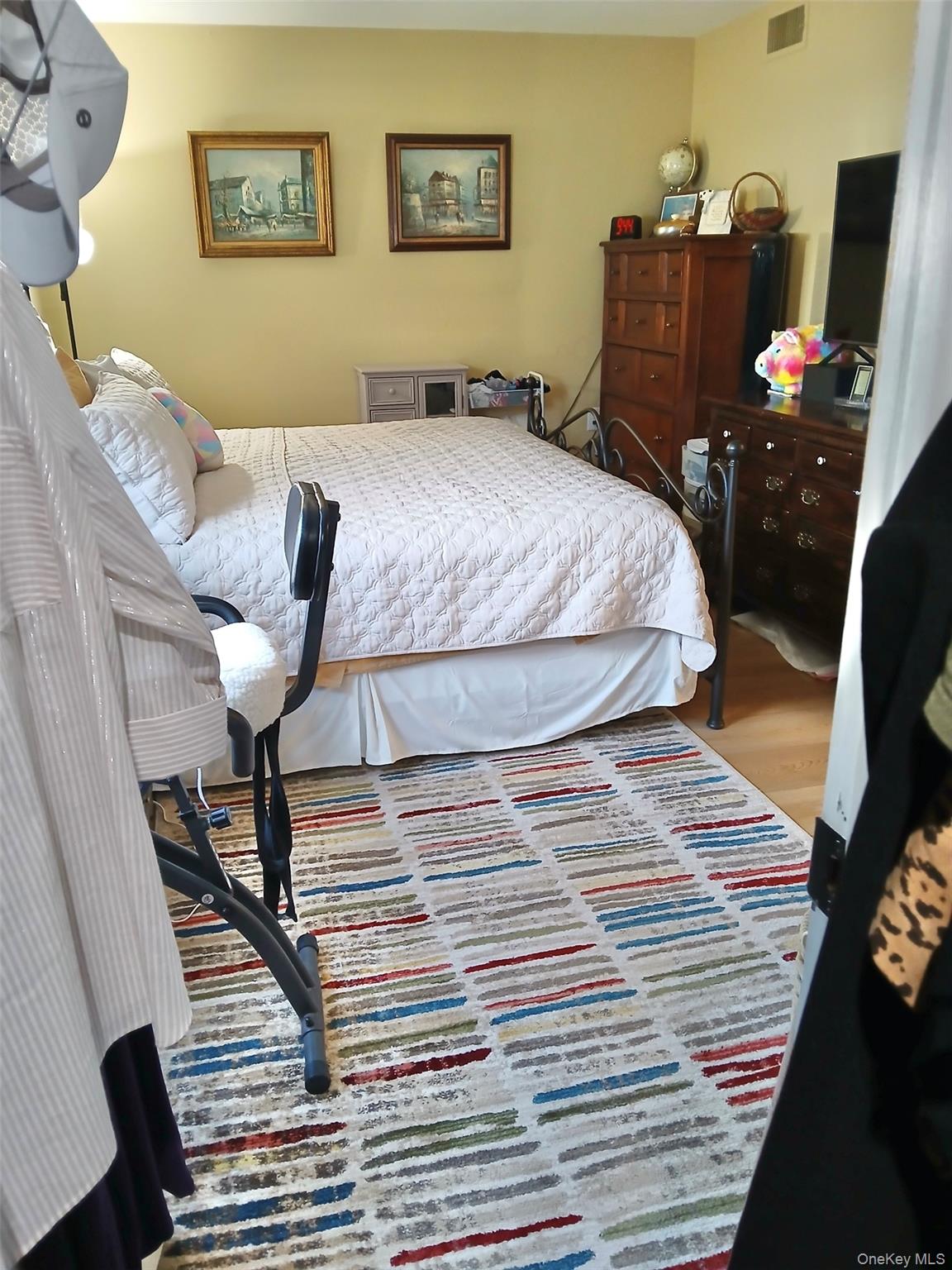 427 Aylesbury Court, Unit A Ridge, NY 11961 - Photo 10 of 16 a bedroom with a bed and wooden floor