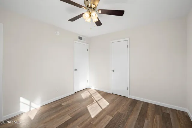 a view of empty room with wooden floor