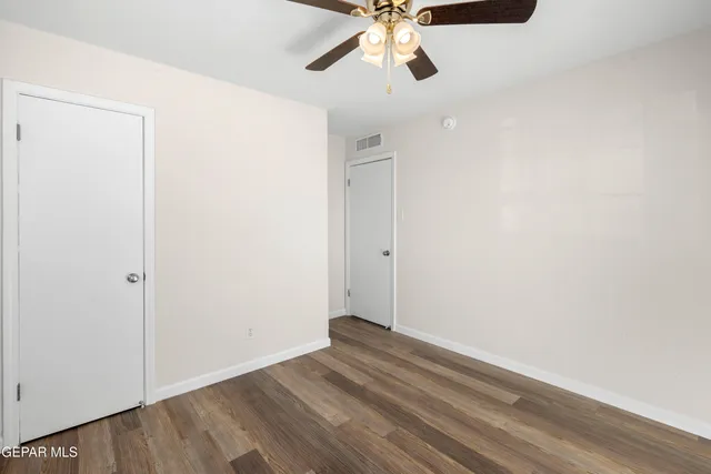 a view of room with wooden floor and fan