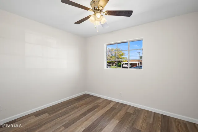an empty room with a window and a ceiling fan