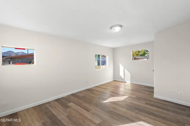 a view of empty room with wooden floor