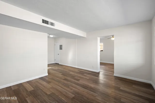 a view of an empty room with wooden floor