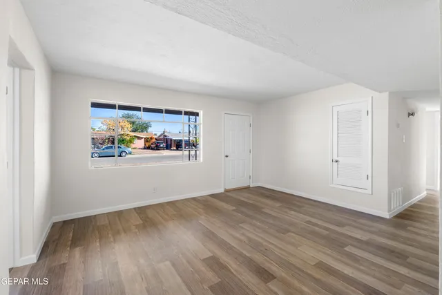 an empty room with wooden floor and window