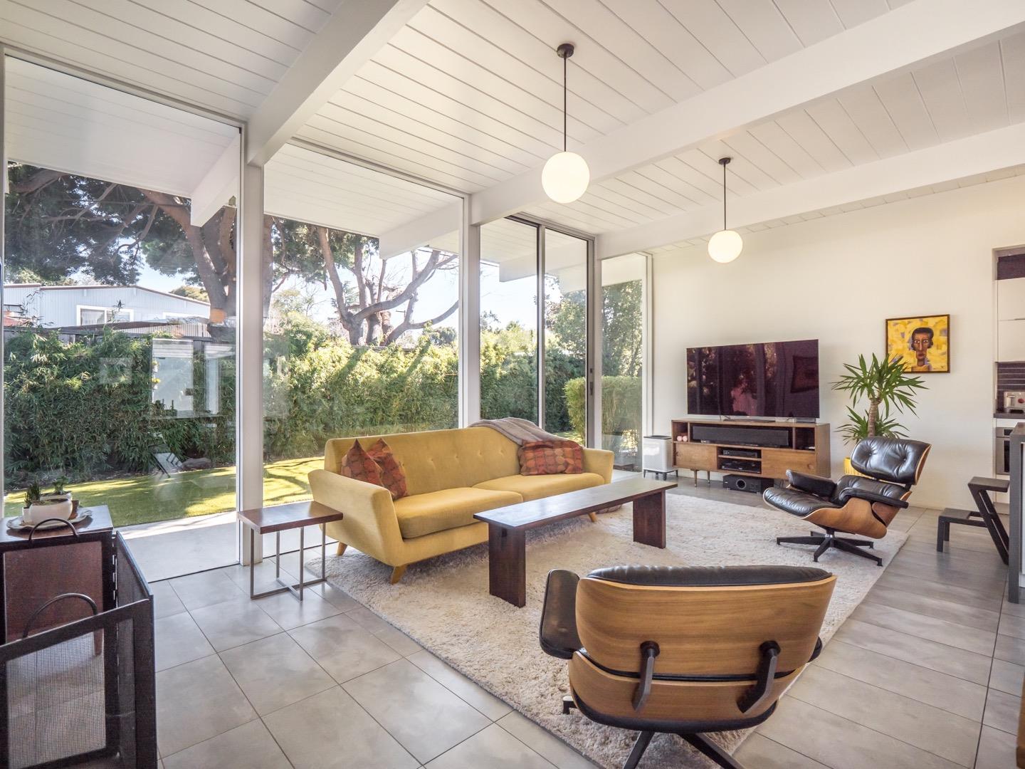 3449 Thomas Drive Palo Alto, CA 94303 - Photo 8 of 59 a living room with couches a coffee table and a large window with garden view