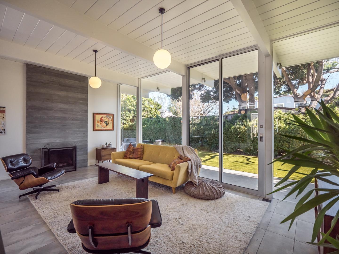 3449 Thomas Drive Palo Alto, CA 94303 - Photo 10 of 59 a living room with furniture a fireplace and a floor to ceiling window