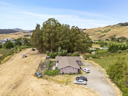 an aerial view of residential houses with outdoor space and river