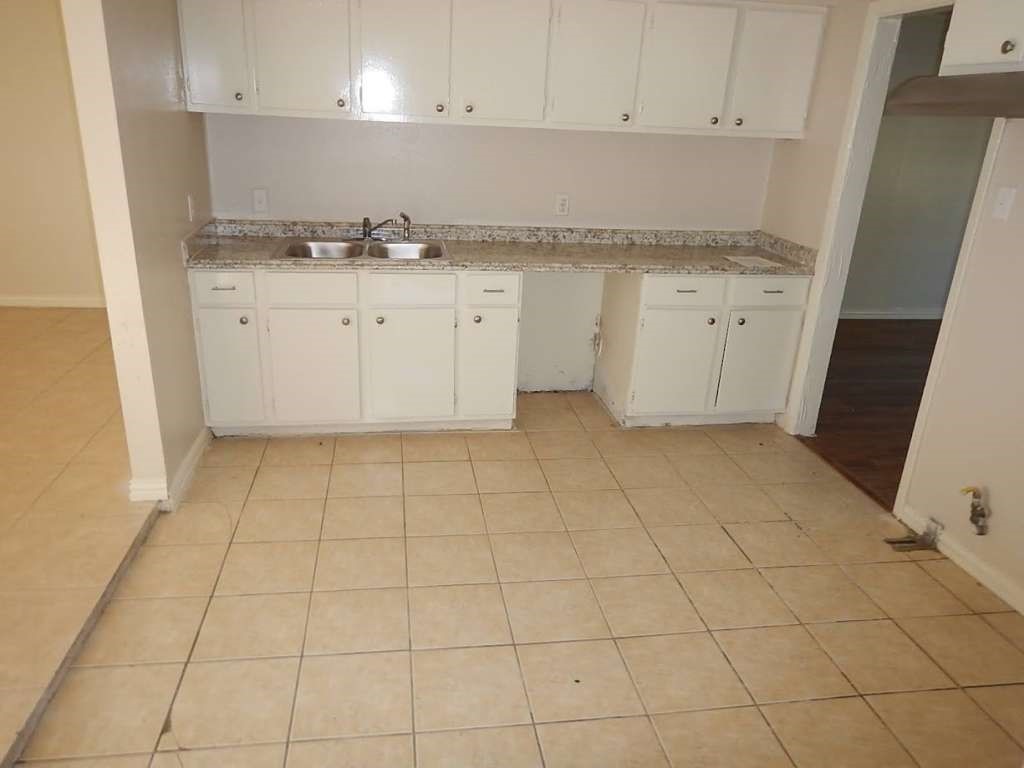 5131 Nassau Road Houston, TX 77021 - Photo 6 of 14 a kitchen with granite countertop white cabinets and a sink