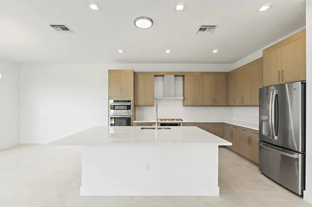 a kitchen with stainless steel appliances granite countertop a refrigerator sink and stove