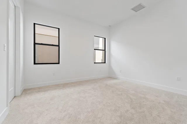 an empty room with windows and closet